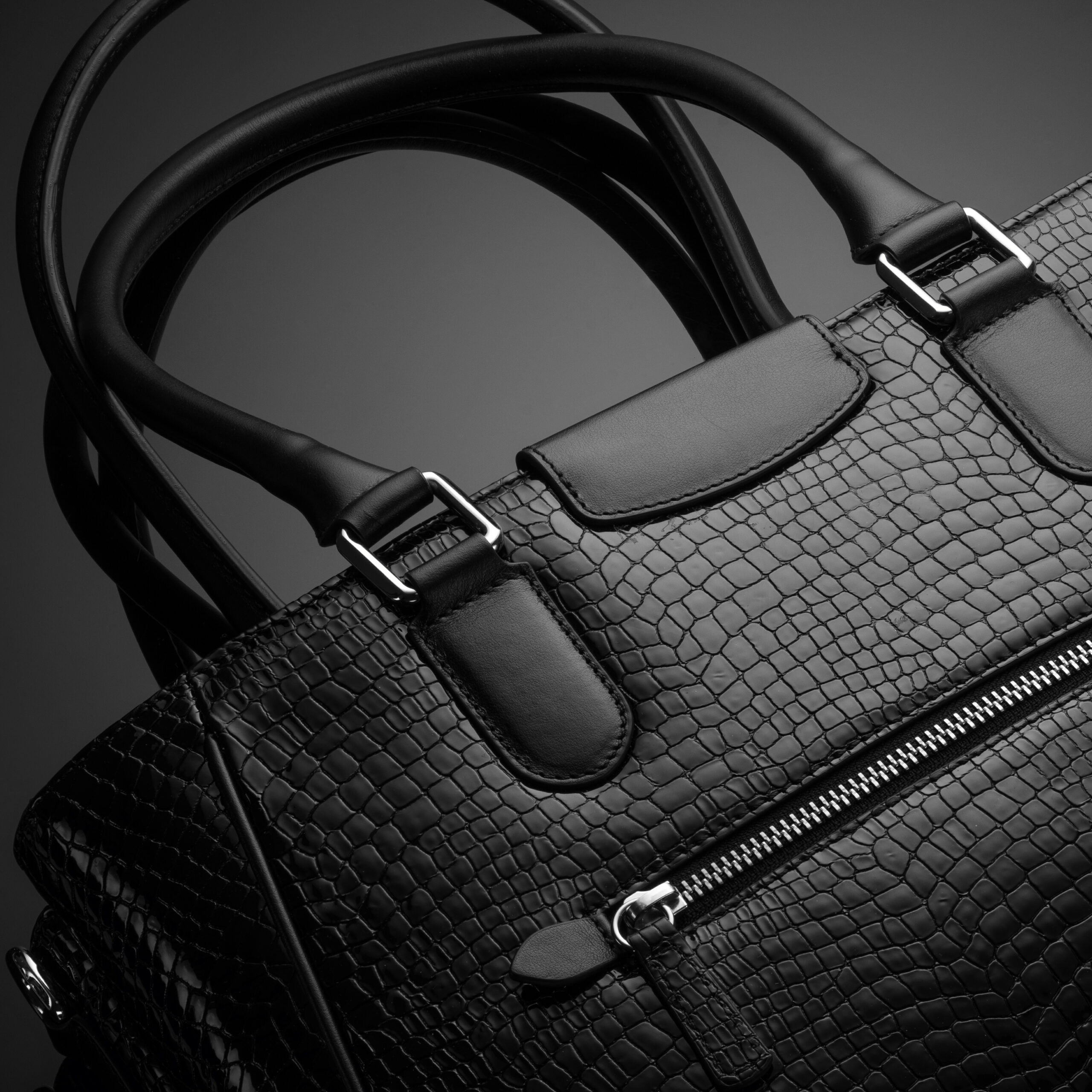 Black designer handbag on dark background