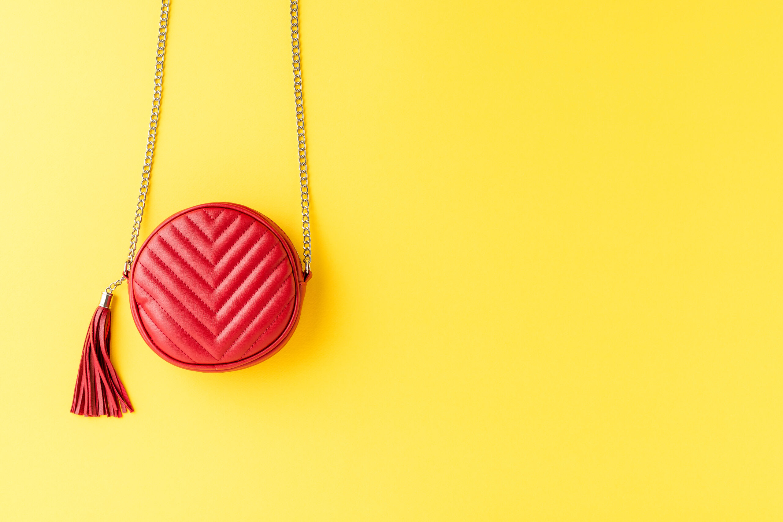 Bright coloured designer purse on yellow background
