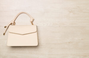 Fashionable leather handbag on wooden background