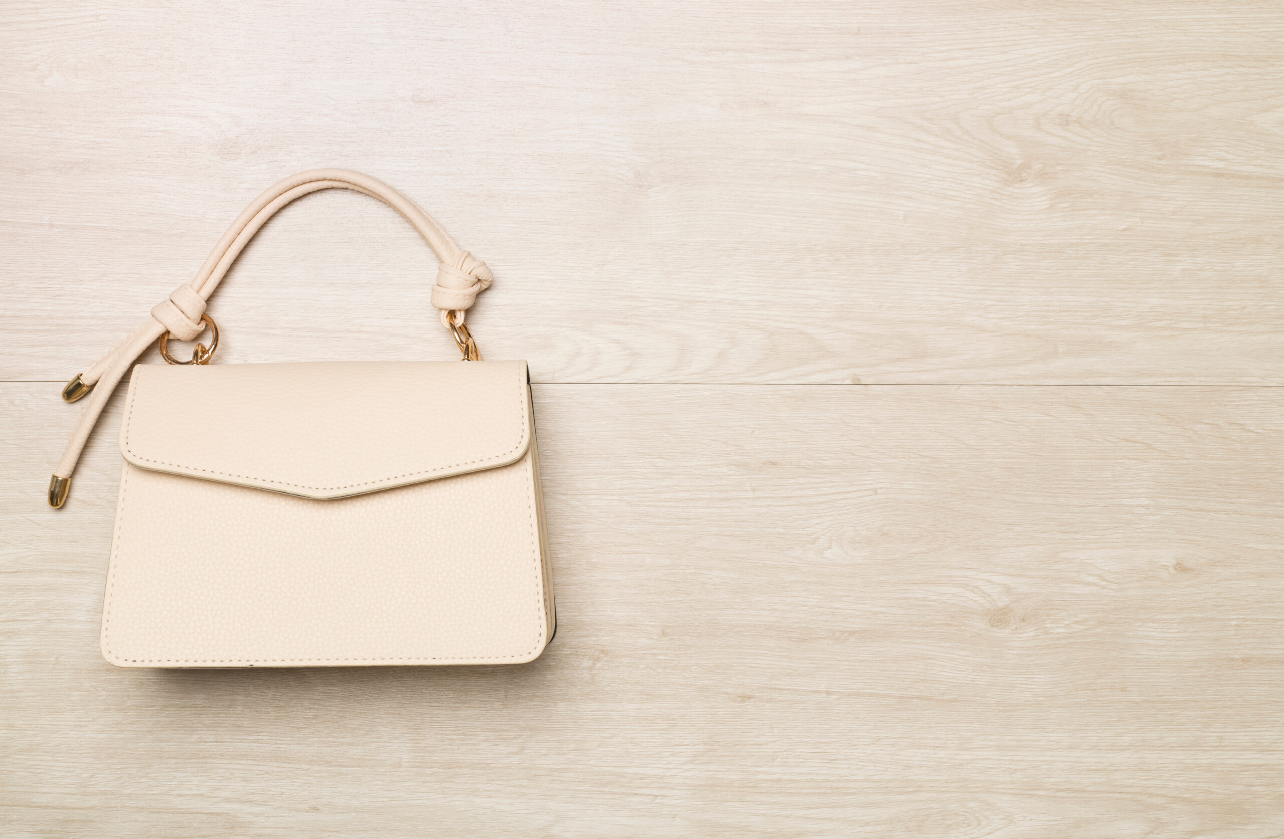 Fashionable leather handbag on wooden background